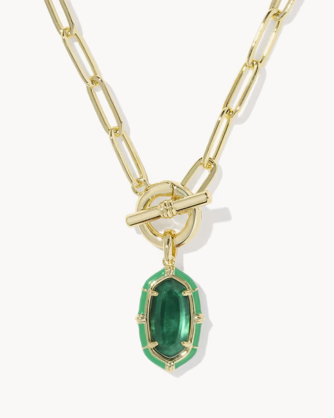 Gold paperclip chain necklace with a toggle clasp and a green enamel pendant featuring gold trim, shown on a light gray background.