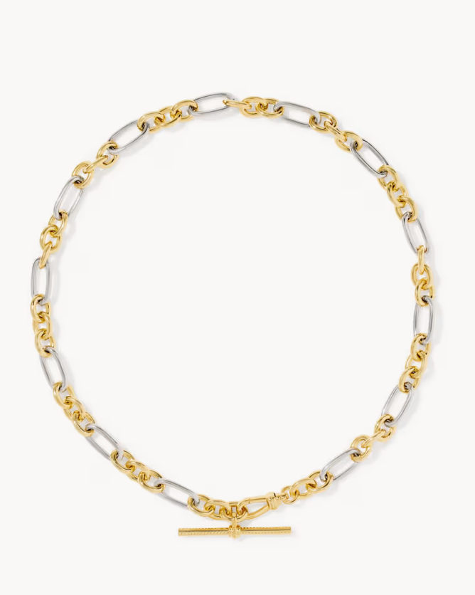 A two-tone mixed metal link chain necklace with elongated oval links in yellow gold and silver-tone metal, featuring a small horizontal bar clasp at the bottom, displayed on a light gray background.